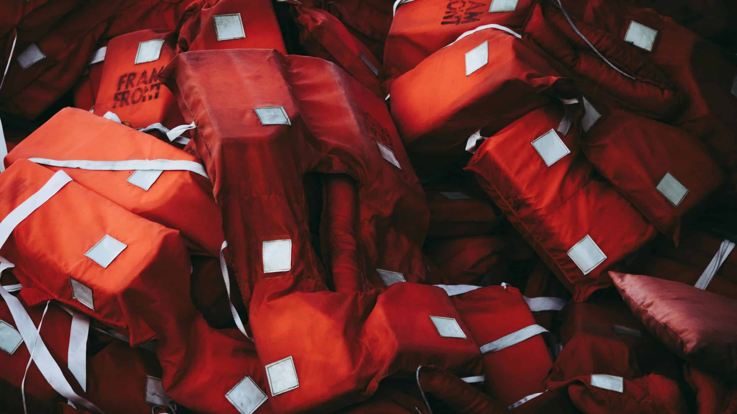 A collection of red life jackets emphasizing safety and emergency preparedness.
